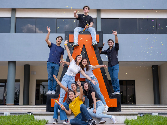 alumnos de la universidad anahuac con confeti y estatua
