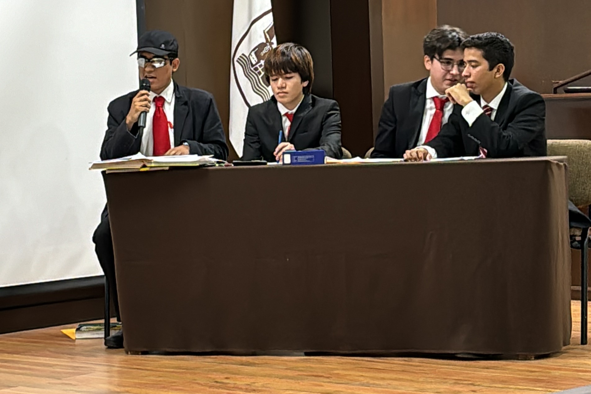 Alumnos de equipo ganador, participando en el debate.