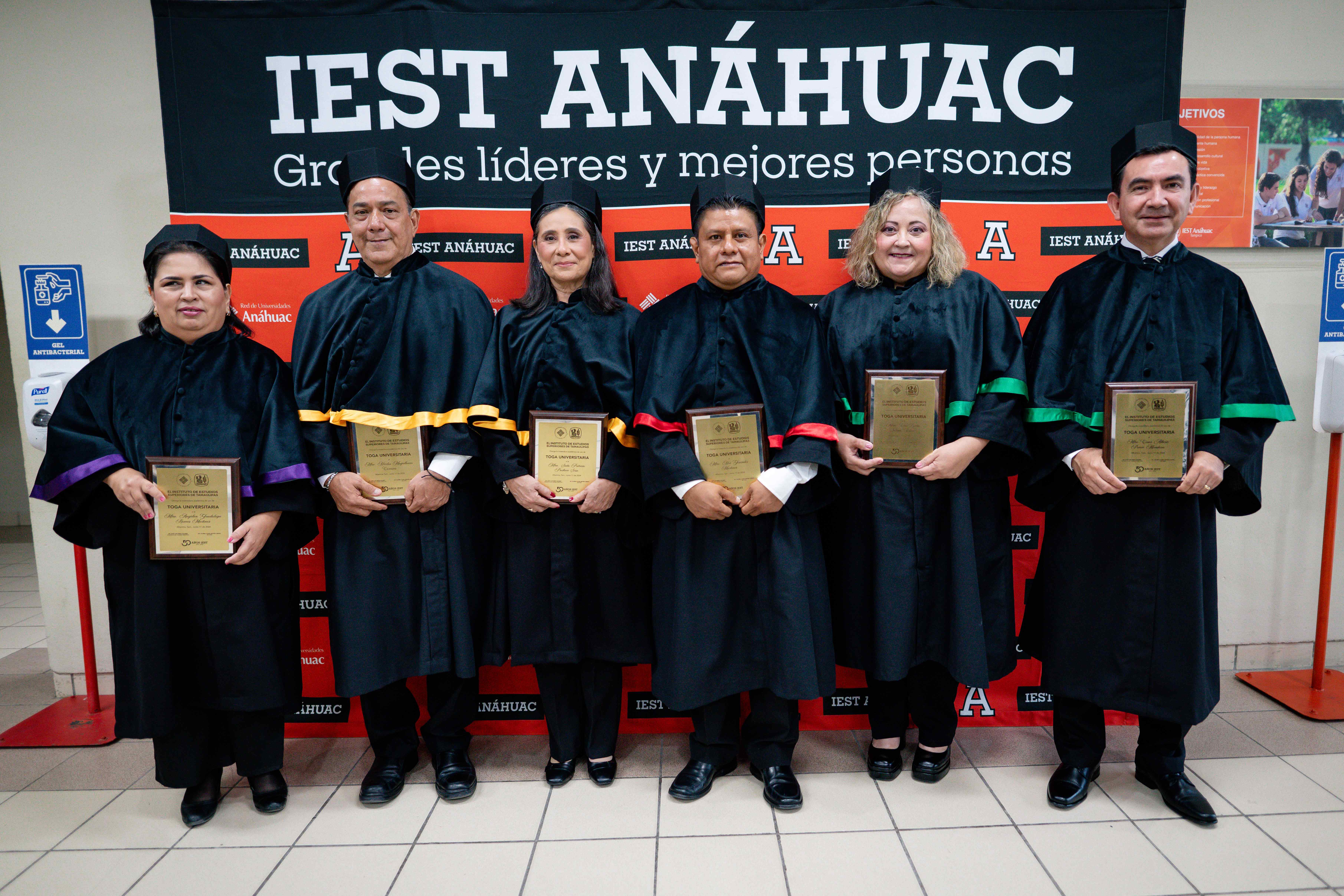 Los nuevos investidos, delante de una mampara, en el vestíbulo del Gimnasio Burton Grossman.