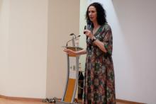 La conferencista de Psicotraumatología con un vestido floreado y extravagante.