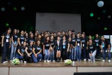 Foto de grupo de organizadores de Proyecciones Empresariales, en el escenario del gimnasio.