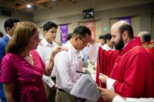 El padre Carlos Moreno impone la mano a uno de los guardias que han recibido el Sacramento de la Confirmación.